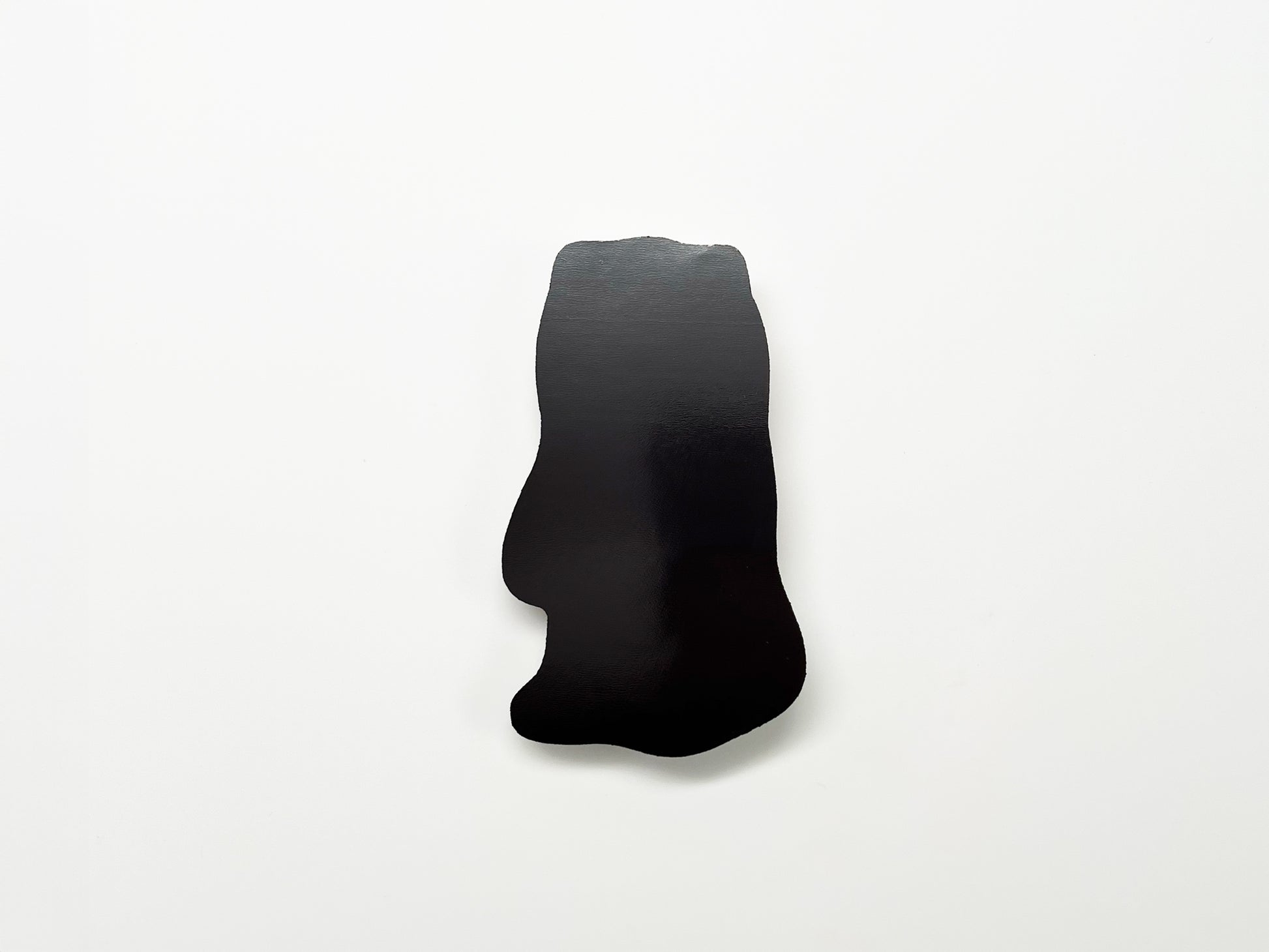 Back view of a handmade die-cut Bigfoot Halloween magnet, showing the smooth black magnetic surface. Durable fridge magnet perfect for holding notes or photos, ideal for Halloween décor, cryptid enthusiasts, and quirky woodland creature gifts.