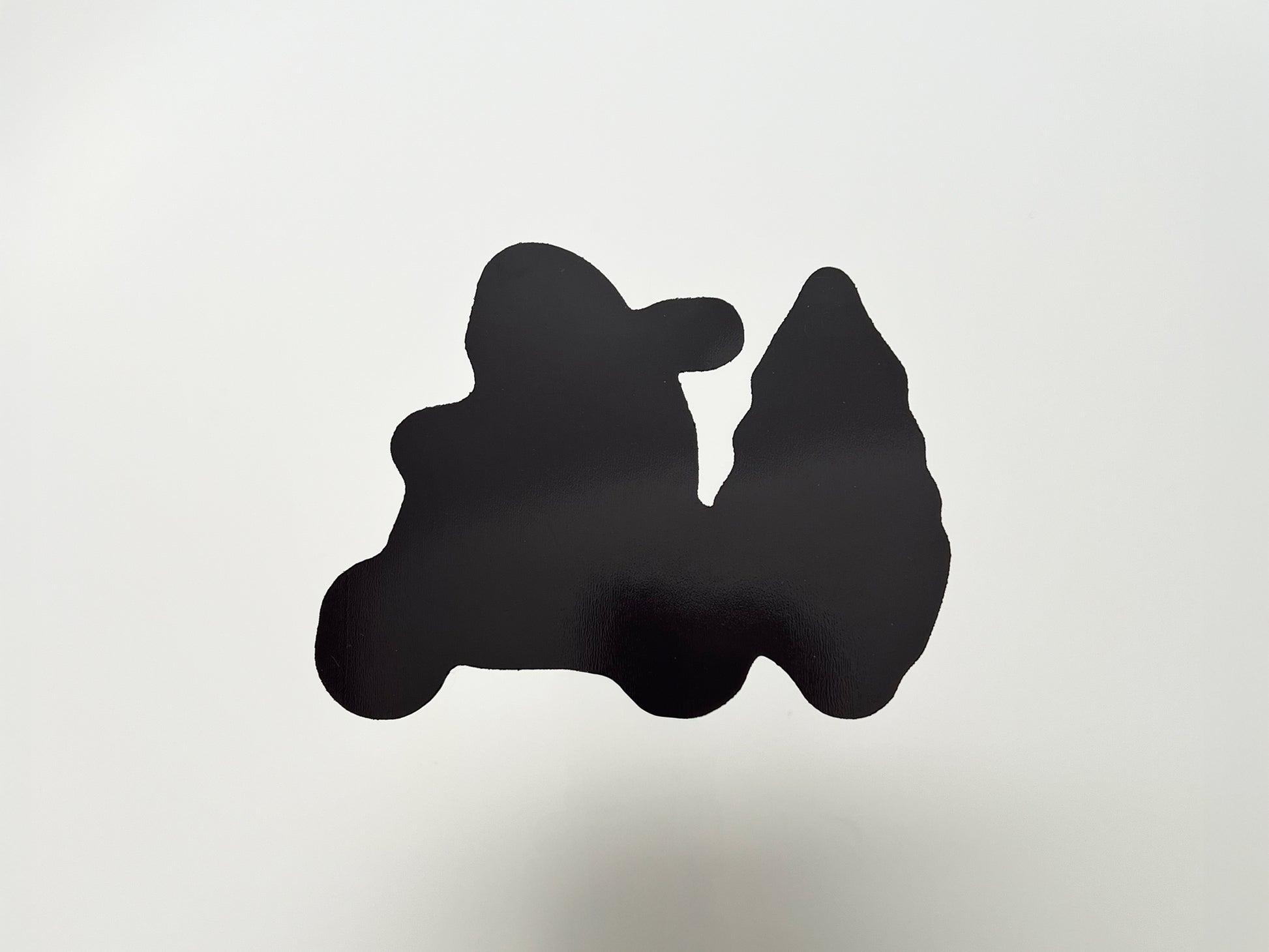 Back view of a handmade die-cut magnet shaped like a yeti riding a scooter and pulling a Christmas tree. The magnet side is solid black with a glossy finish, cut precisely to match the front design, showing durability and strong hold for use on fridges, lockers, or other magnetic surfaces.