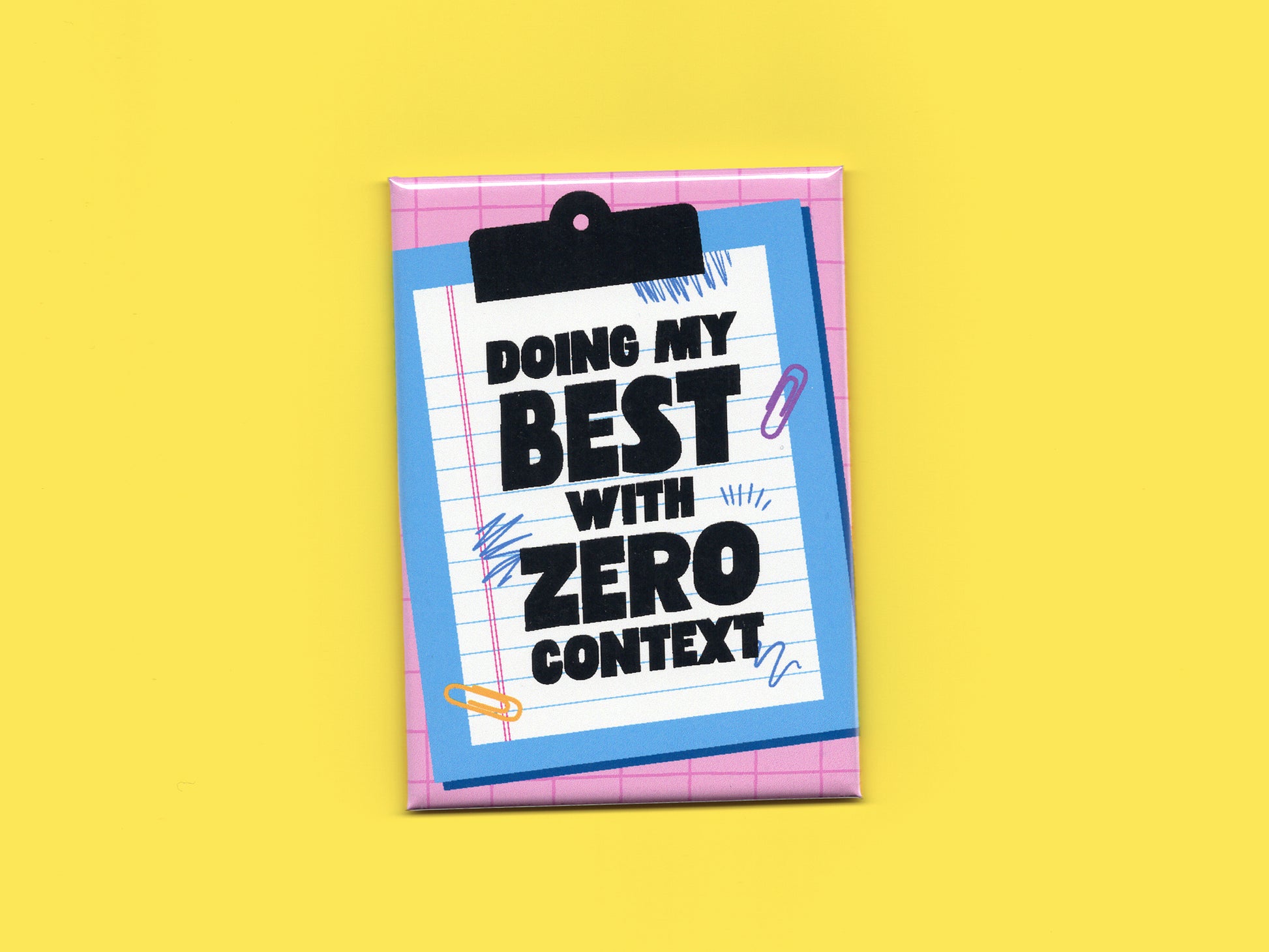 Rectangular magnet with a pink grid background and a blue clipboard illustration holding lined paper. Bold black text reads “Doing My Best With Zero Context.” The magnet is displayed against a bright yellow background.