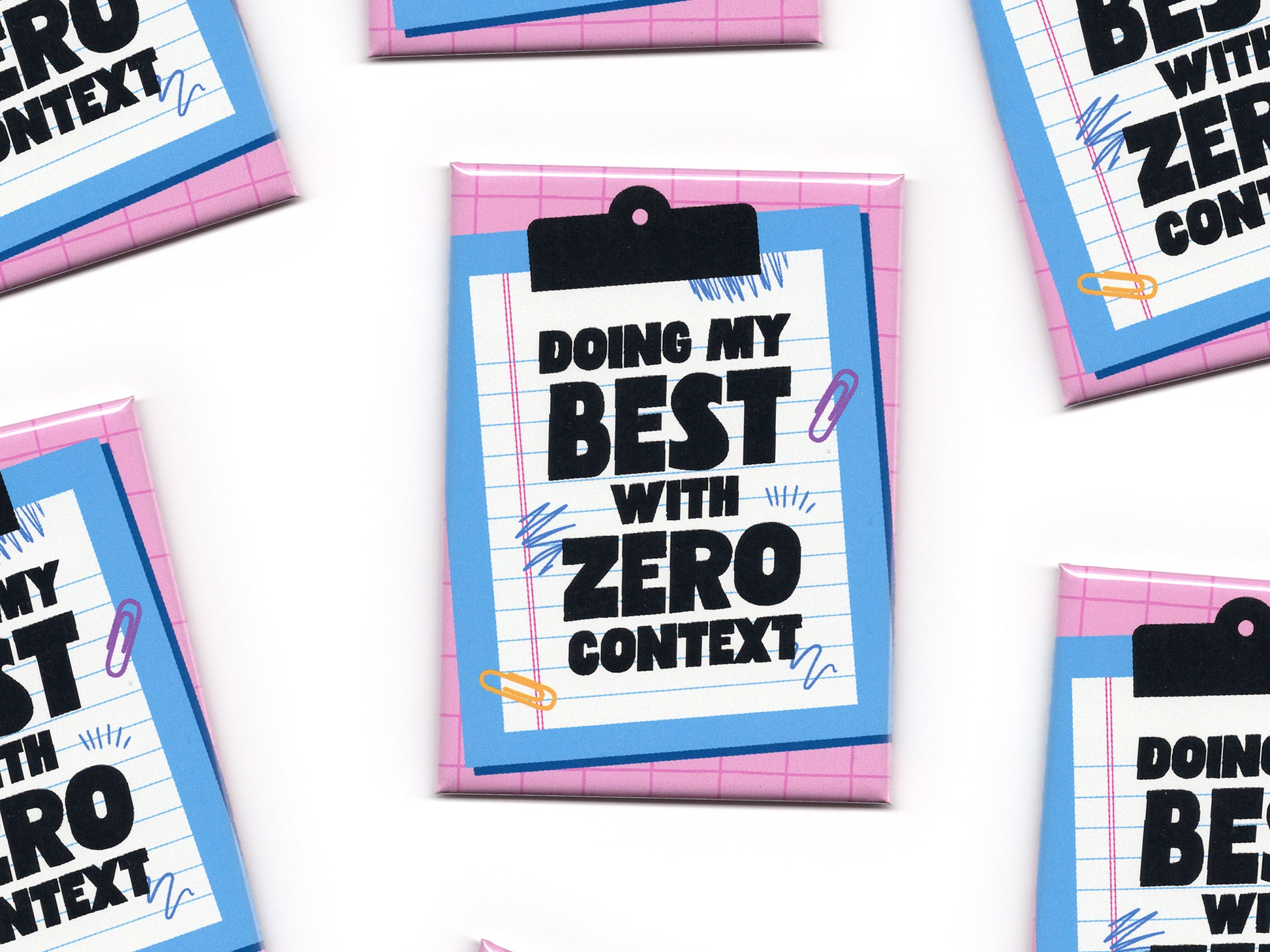 Multiple “Doing My Best With Zero Context” magnets scattered across a white background. The magnets feature a pink grid pattern, a blue clipboard illustration, and bold black text on lined paper.